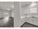 Bright kitchen featuring white cabinets, stainless steel sink, and open layout at 114 Tuscany Villas Dr, Edgewater, FL 32141