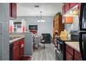 Cozy kitchen with red cabinets, black appliances, eat-in kitchen table at 1170 Calle Del Rey # D, Casselberry, FL 32707