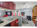 Open kitchen and dining area featuring red cabinets and gray walls at 1170 Calle Del Rey # D, Casselberry, FL 32707