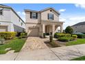Attractive two-story home featuring a paved driveway and manicured landscaping at 1841 Sawyer Palm Pl, Kissimmee, FL 34747