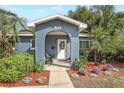 Inviting home entrance with a decorative wreath, a cozy chair, and lush landscaping at 2909 Depauw Ave, Orlando, FL 32804