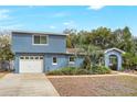 Exterior of a charming blue two-story home with attached garage and well-maintained lawn at 2909 Depauw Ave, Orlando, FL 32804