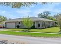 A well-maintained single-story home featuring stone details and an attached two-car garage at 3117 Lake Mar Ln, Orlando, FL 32806