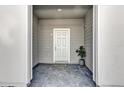 Covered front porch featuring a gray brick floor and gray walls, enhancing curb appeal at 3962 Lana Ave, Davenport, FL 33897