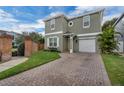 Charming home with a brick-paved driveway, well-maintained lawn, and a brick fence at 5852 Mariposa Cove Ln, Orlando, FL 32822