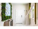 Bright foyer featuring stairs, white door, modern décor, and tiled floors at 7219 Oakmoss Loop, Davenport, FL 33837