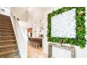 Spacious foyer with staircase, decorative art, and a view into the kitchen area at 7219 Oakmoss Loop, Davenport, FL 33837
