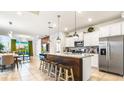 Open concept kitchen with granite counters, stainless steel appliances, and a center island at 7219 Oakmoss Loop, Davenport, FL 33837