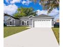 Beautiful home with a two-car garage, gray exterior paint, and a well-manicured lawn at 738 Paris Dr, Kissimmee, FL 34759