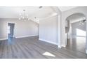 Open-concept living room featuring modern lighting, arched doorways, and stylish laminate flooring at 738 Paris Dr, Kissimmee, FL 34759
