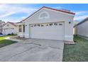 Exterior showcasing a two-car garage with decorative detailing, a red tile roof, and tidy landscaping at 1008 Birkdale Trl, Winter Springs, FL 32708