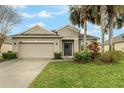 Attractive home featuring a two-car garage, neutral exterior, and green lawn at 105 Adoncia Way, Sanford, FL 32771