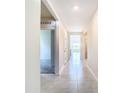 Bright hallway featuring tile flooring and neutral walls, leading to various rooms within the home at 1133 August Sky Dr, Deltona, FL 32738