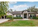 Charming single-story home with a three-car garage, and beautiful curb appeal with lush, manicured landscaping at 1222 Shorecrest Cir, Clermont, FL 34711
