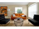 Inviting living room featuring a stylish leather sofa, a unique coffee table, and ample natural light at 131 Sonja Cir # 1, Davenport, FL 33897