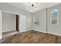 Cozy bedroom with wood floors, neutral walls, arched window, and modern ceiling fan at 16548 Caravaggio Loop, Montverde, FL 34756