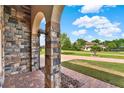 Charming exterior showing brick column, well-kept lawn, and front view of another property at 16548 Caravaggio Loop, Montverde, FL 34756