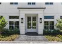 A charming front entry boasts a covered porch with black lanterns and beautiful double doors at 1660 Palmer Ave, Winter Park, FL 32789