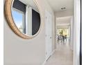 Inviting hallway with neutral walls, tile flooring and a view into a dining area with natural light at 3626 Cambridge Brook Dr, Davenport, FL 33837