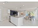 Modern open-concept kitchen with stainless steel appliances, an island, and an adjacent dining area at 3626 Cambridge Brook Dr, Davenport, FL 33837
