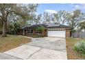 Charming brick home featuring a two-car garage, solar panels, and a well-maintained front yard at 432 Wilderness Dr, Longwood, FL 32779