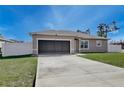 Charming single-story home featuring a well-manicured lawn and attached one-car garage at 702 Pelican Ct, Kissimmee, FL 34759