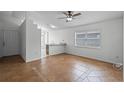 Bright living room featuring tile flooring, a ceiling fan and a pass-through to the kitchen at 8519 Rainbow Ave, Orlando, FL 32825