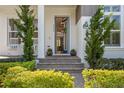 Inviting front porch with elegant blue door, paver steps, and manicured landscaping at 9454 Becker Ct, Orlando, FL 32827