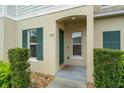 Inviting front entrance featuring decorative shrubs, green shutters, and charming front door at 157 Primrose Dr, Davenport, FL 33837
