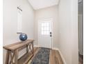 Bright foyer with a decorative table, rug, and a front door with glass panes at 1965 3Rd Dr, Sanford, FL 32771