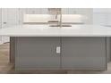 Close-up of the kitchen island with a white countertop, stainless steel sink, and light gray base at 2120 Antilles Club Dr # 10, Kissimmee, FL 34747