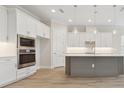 Modern kitchen featuring white cabinets, stainless steel appliances, and an island with pendant lighting at 2120 Antilles Club Dr # 10, Kissimmee, FL 34747