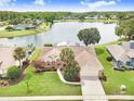 Aerial view of a beautiful home with a well-manicured lawn and picturesque lake view at 2732 Lone Feather Dr, Orlando, FL 32837