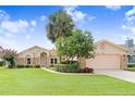 Beautiful single-Gathering home with a brick accent, manicured lawn and tropical landscaping at 2732 Lone Feather Dr, Orlando, FL 32837