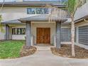 Elegant front entrance featuring a double door entry, glass block window and modern grey pillars at 303 Waterwood Dr, Yalaha, FL 34797