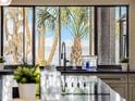Kitchen view featuring a large window showcasing lush vegetation and ocean views at 303 Waterwood Dr, Yalaha, FL 34797
