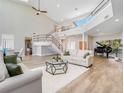 Spacious living room with high ceilings, modern staircase, a piano and lots of natural light at 303 Waterwood Dr, Yalaha, FL 34797