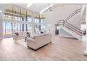Open-concept living room with staircase, water views, and modern decor at 303 Waterwood Dr, Yalaha, FL 34797
