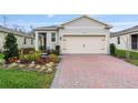 Charming home featuring a well-manicured garden and a brick driveway at 3412 Yellowtop Loop, Clermont, FL 34714
