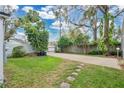 The backyard features mature trees and a long driveway with stone pavers at 4522 Flagg St, Orlando, FL 32812