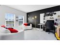 Bright living room with white marble floors, black accent wall, modern decor, and large windows providing natural light at 4698 Marcos Cir, Kissimmee, FL 34758