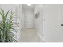 Bright hallway with white doors and trim, enhanced by marble floors and plant decorations at 4849 Cypress Woods Dr # 1308, Orlando, FL 32811