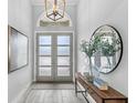 Elegant foyer with a console table, mirror, vases, and wood-look tile flooring at 534 Two Lakes Ln, Eustis, FL 32726