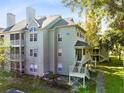 View of the condo community with exterior stairs, balcony and green surroundings at 6178 Westgate Dr # 304, Orlando, FL 32835