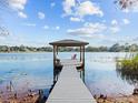 Scenic view of a private wooden dock and gazebo on a calm lake under a sunny sky at 641 Lake Catherine Dr, Maitland, FL 32751