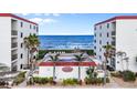 Exterior daytime view features the condo complex, pool, landscaping, and beach access at 6727 Turtlemound Rd # 417, New Smyrna Beach, FL 32169