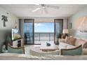 Bright living room with a ceiling fan and sliding glass doors to the ocean-view balcony at 6727 Turtlemound Rd # 417, New Smyrna Beach, FL 32169