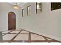 Elegant foyer with tiled floors, arched wooden door, and natural light from multiple windows at 8149 Via Vittoria Way, Orlando, FL 32819