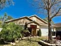 Beautiful single-story home boasting lush landscaping, a well-kept lawn, and a two car garage at 15688 Galbi Dr, Orlando, FL 32828