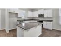 Bright kitchen featuring granite countertops, stainless steel appliances, and white cabinetry with ample storage space at 18058 Cider Mill Ln, Winter Garden, FL 34787